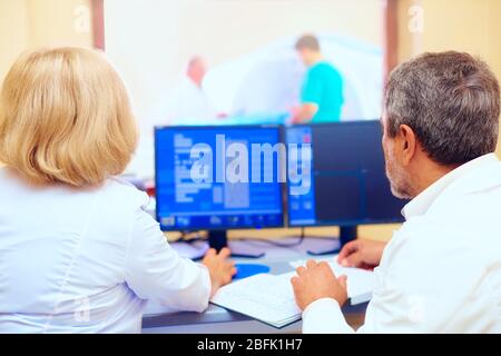 personale medico che discute i risultati della rm durante la procedura Foto Stock