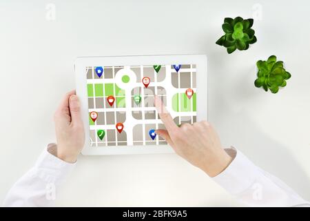 Donna che utilizza un tablet con applicazione di navigazione gps con mappe, vista dall'alto Foto Stock