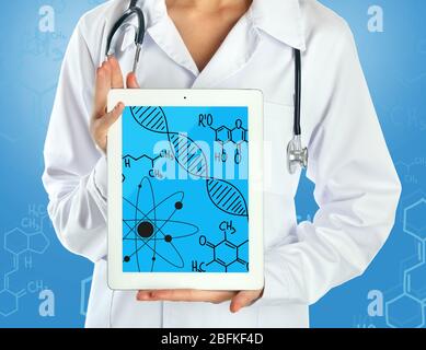 Giovane medico che tiene il PC-compressa con molecola di DNA sullo schermo Foto Stock