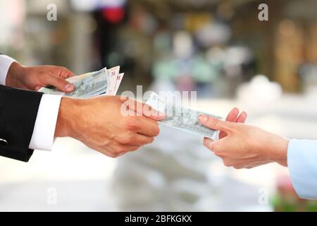 La mano della donna prende i soldi dalla mano dell'uomo Foto Stock