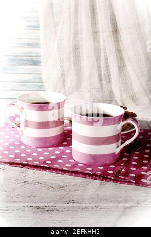 Due tazze di caffè su tovagliolo sul tavolo su sfondo bianco tenda Foto Stock