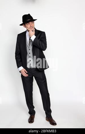 Bel gangster di mezza età che posa in studio su sfondo isolato. Stile, eleganza, business, gentiluomo, concetto di moda. Foto Stock