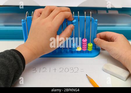 kid usando abacus per calcolare l'equazione di addizione Foto Stock