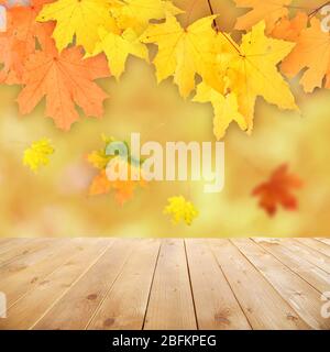 Foglie autunnali con bokeh e pavimento in legno. Bellissimo sfondo autunnale naturale Foto Stock