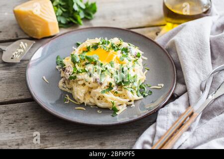 Spaghetti Carbonara con pancetta, formaggio e tuorlo d'uovo. Fuoco selettivo Foto Stock