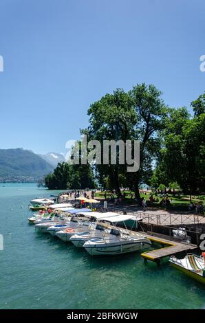 Barche disponibili in affitto ancorate sulle rive del Lago di Annecy in Francia Foto Stock