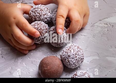 Baby in possesso di palle di energia sana, palle di cioccolato per la colazione. Non c'è cibo di concetto del glutine Foto Stock