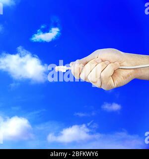 Cavo Internet in mano su sfondo blu cielo con nuvola Foto Stock