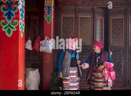 Due donne anziane che parlano all'interno del tempio buddista di Ringo, Shangri la, Cina 2019 Foto Stock