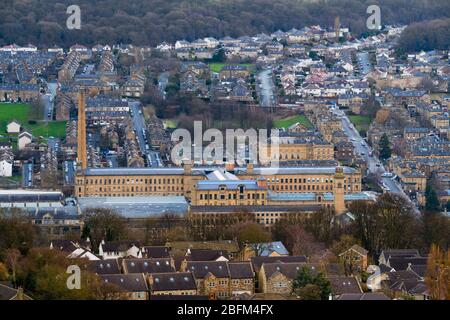 Storico e impressionante mulino vittoriano (galleria d'arte) nella valle di Aire, alto camino torreggiante sopra le case - Saltar Mill, Saltaire, Bradford Inghilterra Regno Unito Foto Stock