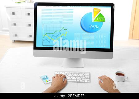 Uomo che lavora con un computer moderno, con schema sullo schermo Foto Stock