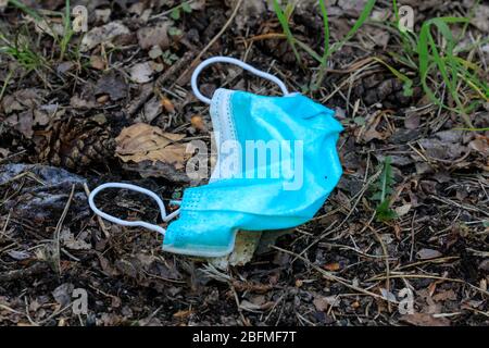 Haltern am See, NRW, Germania. 19 Apr 2020. Una maschera facciale è stata scartata casualmente nel bosco. Sebbene non sia ancora obbligatorio indossare maschere in tutti gli stati federali tedeschi, alcuni stati ora richiedono maschere sui trasporti pubblici e mentre fanno shopping. Nel complesso, i tedeschi finora si sono mantenuti abbastanza bene alle regole di allontanamento sociale e alle restrizioni per la vita pubblica, con i tassi di infezione che si livellano lentamente e i primi segnali indicano che le misure stanno funzionando. Credit: Imageplotter/Alamy Live News Foto Stock