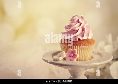 Gustoso cupcake in piedi, su sfondo chiaro Foto Stock