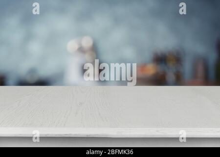 Tavolo vuoto in legno e sfondo sfocato della cucina Foto Stock