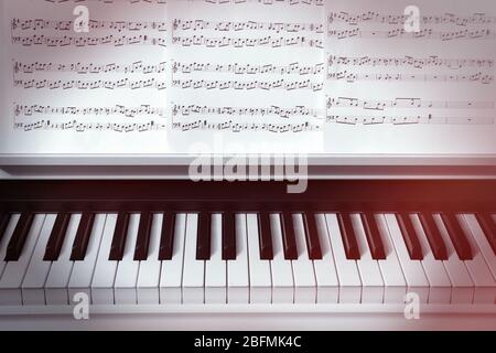 Tastiera per pianoforte e note musicali da vicino Foto Stock