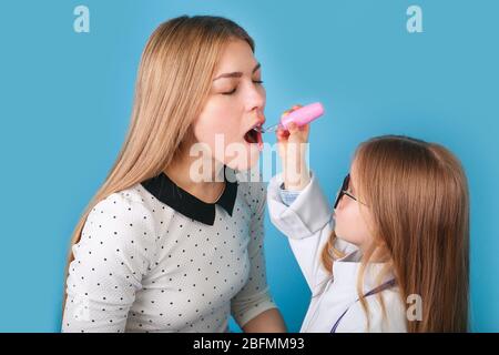 Adorabile bambino vestito da medico che gioca con la madre Foto Stock