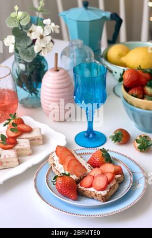 Toast al formaggio fresco con fragole accompagnato da una bevanda rossa. Foto Stock