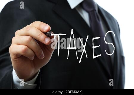 Concetto fiscale. Businessman che scrive TAXS sullo schermo primo piano Foto Stock