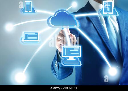 Uomo che preme il pulsante del cloud computing touch sullo schermo virtuale Foto Stock