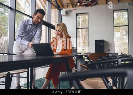 Una donna d'affari entusiasti e focalizzata che si trova sullo schermo di un notebook Foto Stock