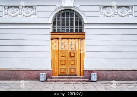 Ingresso porte ad arco sullo sfondo di un muro grigio con stucco e due urne ai lati. Dalle porte della serie mondiale. Foto Stock