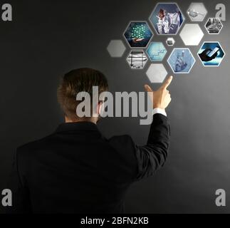 Uomo con anteprima digitale di foto di business su schermo virtuale, concetto di tecnologia moderna Foto Stock