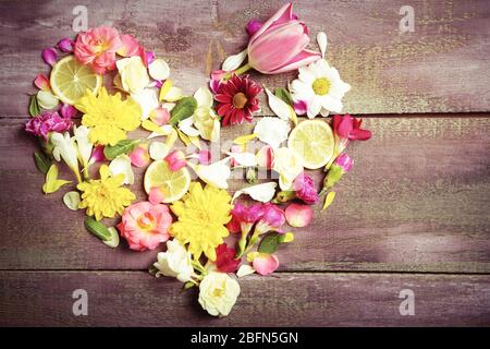 Fiori a forma di cuore su sfondo di legno Foto Stock