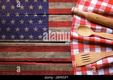 Tovagliolo a scacchi e posate su sfondo di legno. Cucina americana concetto di cibo Foto Stock