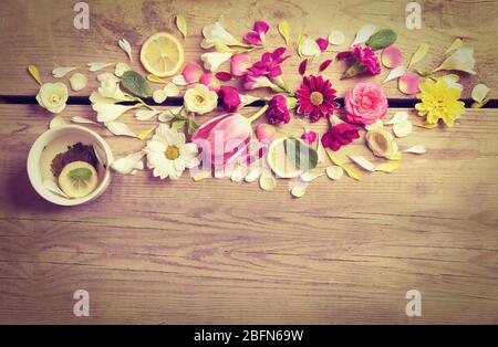 Tazza di tè con splendidi fiori su sfondo di legno Foto Stock