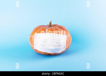 La zucca arancione indossa una maschera medica protettiva, la seconda ondata di autunno di infezione da coronavirus, Halloween e il concetto covid-19. Blocco del coronavirus Foto Stock
