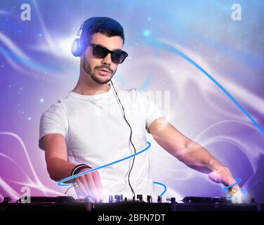 DJ che riproduce musica al mixer su sfondo a colori Foto Stock
