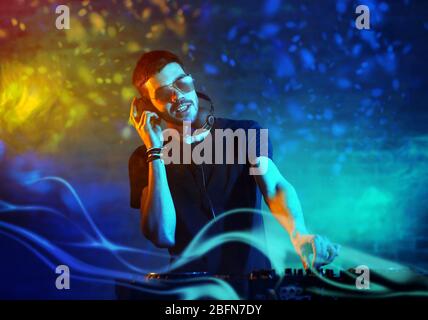 DJ che suona musica al mixer su sfondo foggy Foto Stock