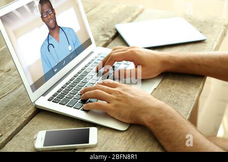 Uomo che parla video con il medico su un notebook. Concetto di consultazione professionale online medica. Foto Stock