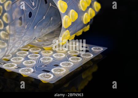 Scheda elettronica a circuito flessibile sulla membrana interna della tastiera. Dettagli pulsanti in silicone. Still life artistica di Bendy PCB. Mirroring degli interruttori a cupola gialli. Foto Stock