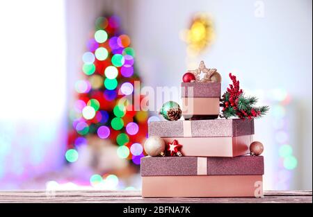 Bei regali di Natale sulla tabella contro sfondo di abete sfocato Foto Stock