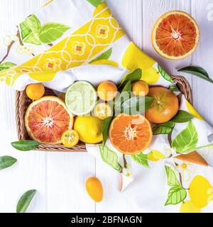 Mix di agrumi freschi in cesto su sfondo di legno bianco Foto Stock