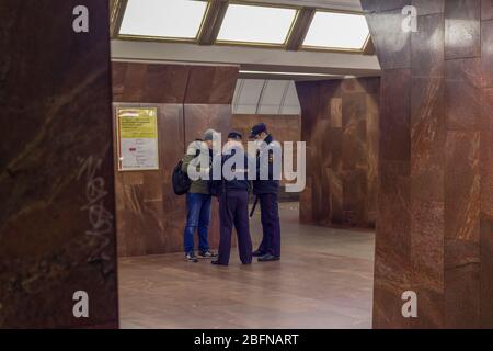 Mosca, Russia - 17 aprile 2020: Poliziotto controlla i documenti di cittadino una piattaforma in metropolitana. Collegamento con COVID-19, effetto controllo accessi. Foto Stock
