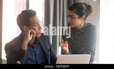 Il team leader indiano femminile condivide le idee con il collega maschile africano Foto Stock