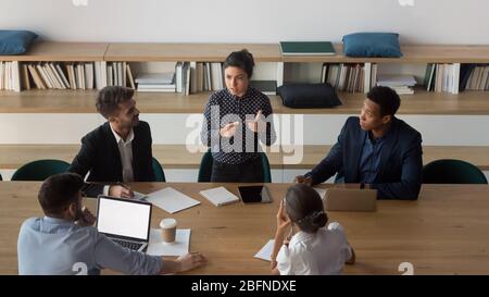 Vista dall'alto, uomini d'affari multietnici che negoziano nella moderna sala riunioni Foto Stock