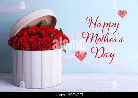 Testo GIORNO DELLA MADRE FELICE sullo sfondo. Regalo su tavolo in legno Foto Stock