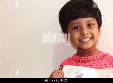 Una bambina piccola con faccia sorridente e sfondo bianco morbido sembra molto bello Foto Stock