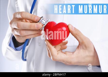 Cardiologia e concetto di assistenza sanitaria. Mani del medico con cuore e stetoscopio Foto Stock