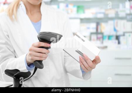 Cassa femminile che scansiona il codice a barre sulla confezione in negozio Foto Stock