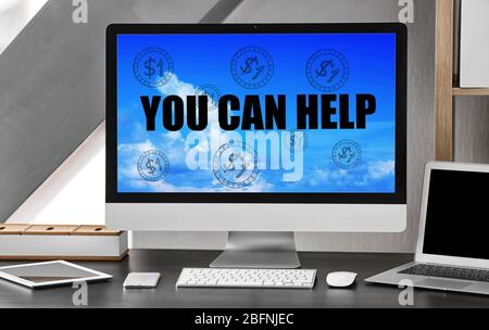 Luogo di lavoro con computer e testo CHE SI PUÒ AIUTARE a schermo. Concetto di beneficenza e volontariato Foto Stock