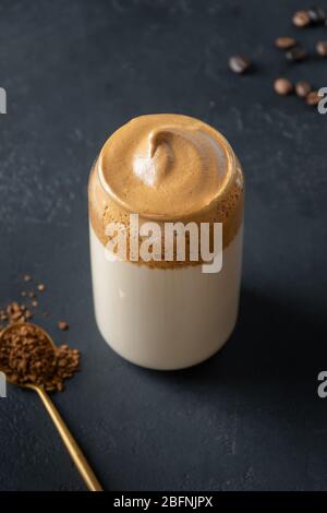 Dalgona caffè in vetro su nero. Trend korean Iced caffè latte bevanda con schiuma di caffè istantaneo. Inquadratura verticale. Foto Stock