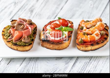 Assortimento di bruschette italiane con diversi condimenti Foto Stock