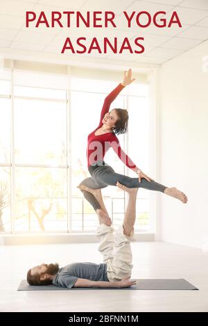 Giovane donna che pratica acro yoga con partner al chiuso Foto Stock