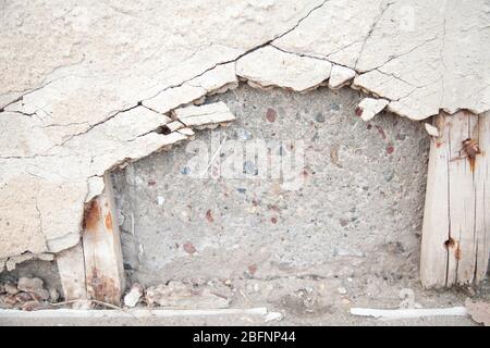 Copertura in calcestruzzo grintoso rotta su blocchi di cemento. Cemento usurato che cade da un muro. Sfondo astratto strutturato. Foto Stock