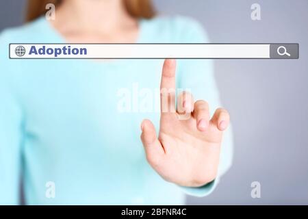 Concetto di adozione. Mano femminile che spinge sulla casella di ricerca Foto Stock