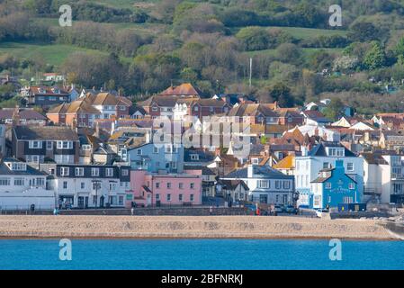 Lyme Regis, Dorset, Regno Unito. 19 Apr 2020. Tempo in Gran Bretagna: La graziosa località costiera è bagnata dal caldo sole del tardo pomeriggio. La città è molto più tranquilla del normale, come la gente osserva le distanze sociali durante il blocco coronavirus. Credit: Celia McMahon/Alamy Live News Foto Stock